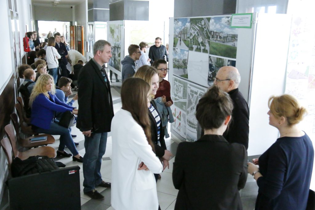 Ludzie oglądają wystawę projektów architektonicznych. Wystawa, ludzie, korytarz.