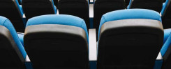 Puste, niebiesko-czarne fotele kinowe ustawione w rzędach. Kontekst: sala kinowa, teatr, aula.